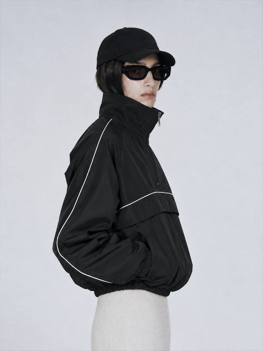 Modèle portant une veste noire Gallenn sur fond gris clair