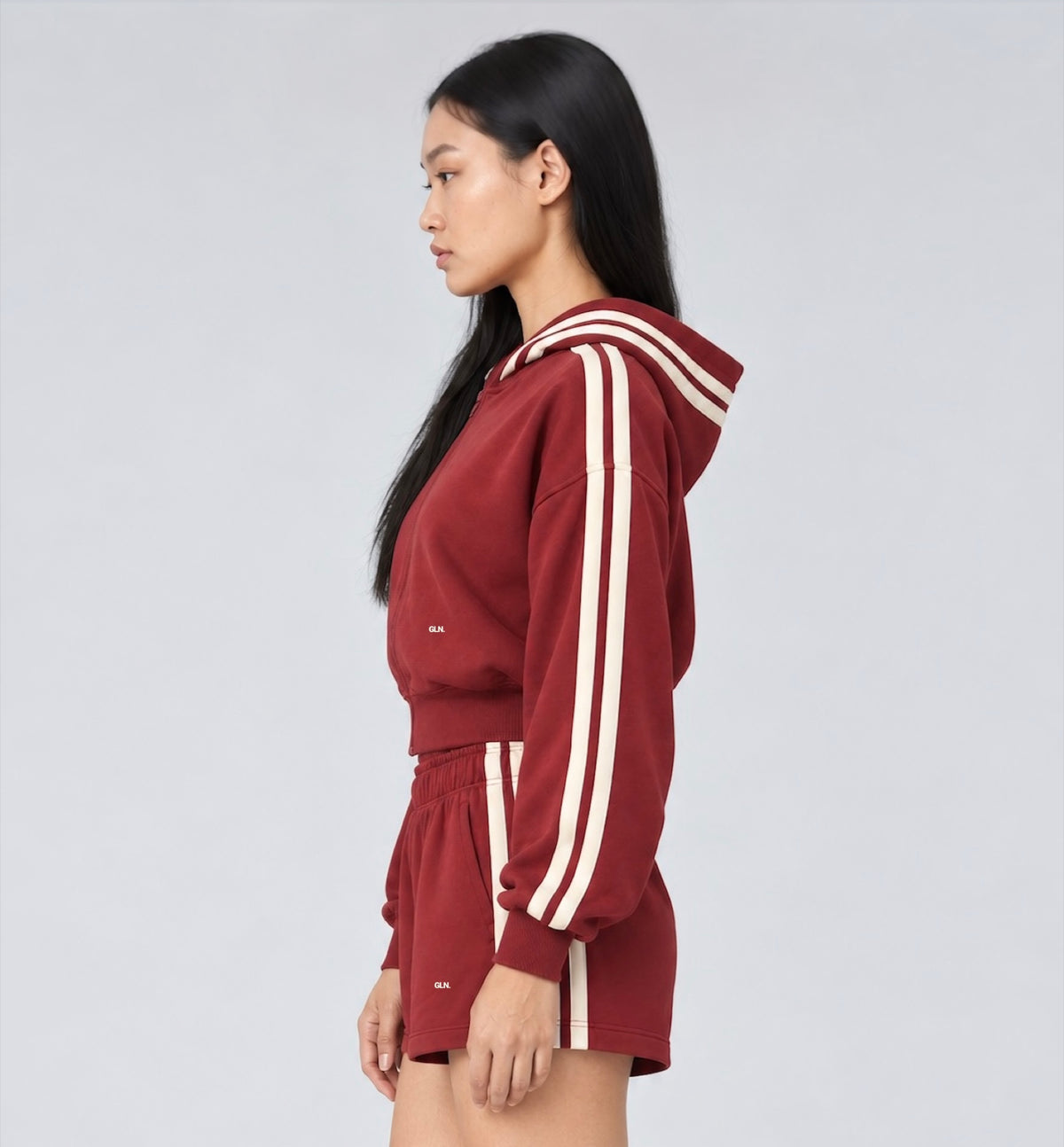 The Weekender Zip-Up Hoodie in Burgundy by Gallenn – model side with cream contrast stripes