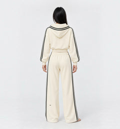 The Weekender Pants in Beige by Gallenn – model back view with wide legs and black side stripes, worn with the matching hoodie