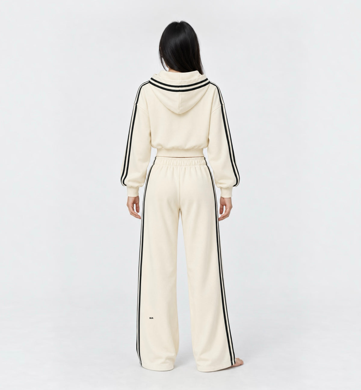 The Weekender Pants in Beige by Gallenn – model back view with wide legs and black side stripes, worn with the matching hoodie