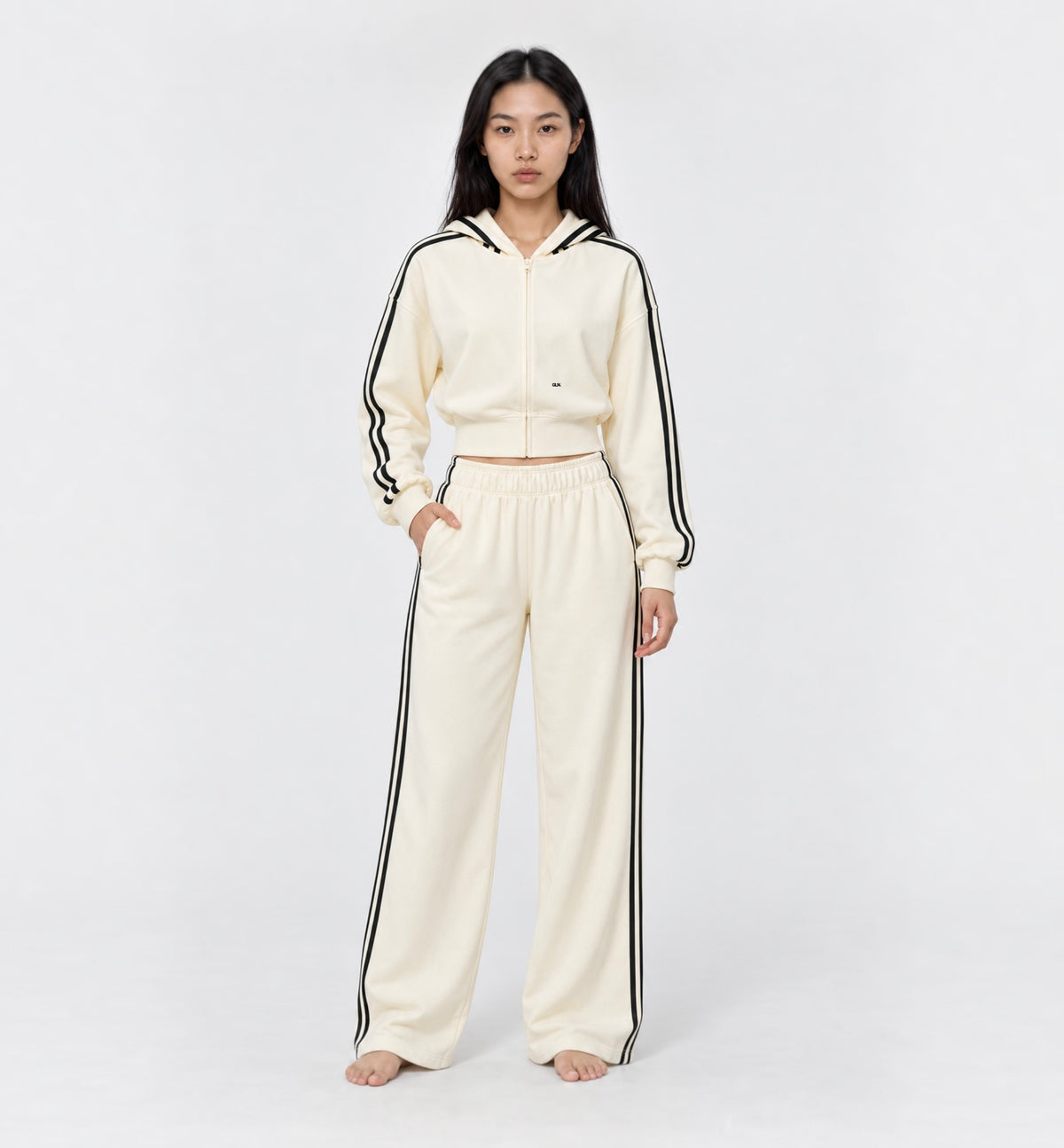 The Weekender Pants in Beige by Gallenn – model front view with wide legs and black side stripes, worn with the matching hoodie