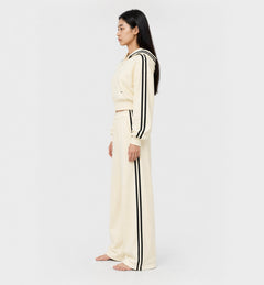 The Weekender Pants in Beige by Gallenn – model side view with wide legs and black side stripes, worn with the matching hoodie