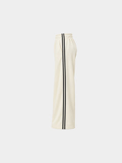 The Weekender Pants in Beige by Gallenn – product side view with wide legs and black side stripes