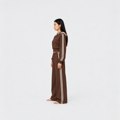 The Weekender Pants in Coffee by Gallenn – model side view, wide legs and cream side stripes, worn with the matching hoodie