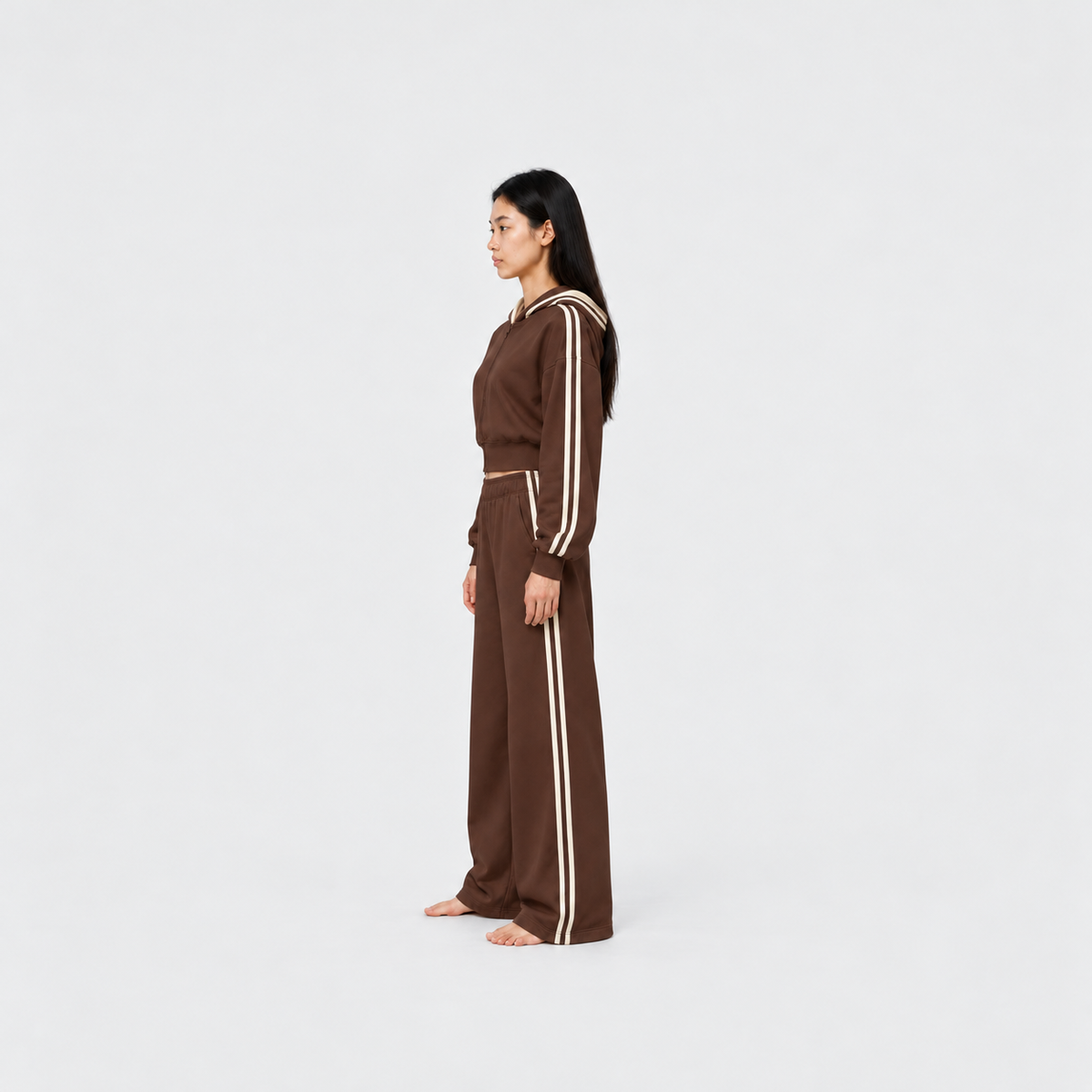 The Weekender Pants in Coffee by Gallenn – model side view, wide legs and cream side stripes, worn with the matching hoodie
