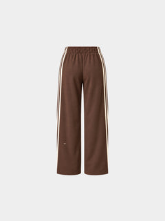 The Weekender Pants in Coffee by Gallenn – product back view with wide legs and cream side stripes